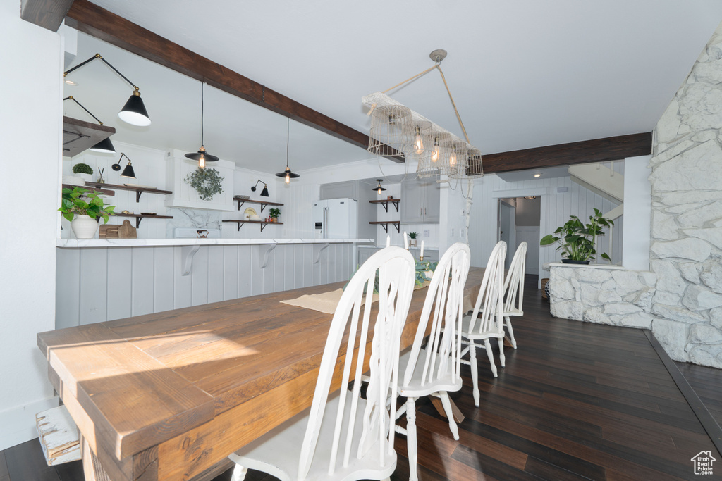 Dining space featuring beam ceiling and dark hardwood / wood-style flooring