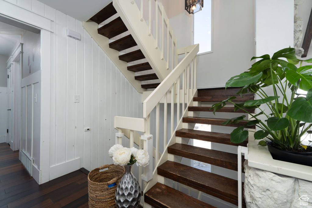 Staircase with wood walls and wood-type flooring