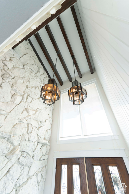 Interior details featuring french doors, beamed ceiling, and an inviting chandelier