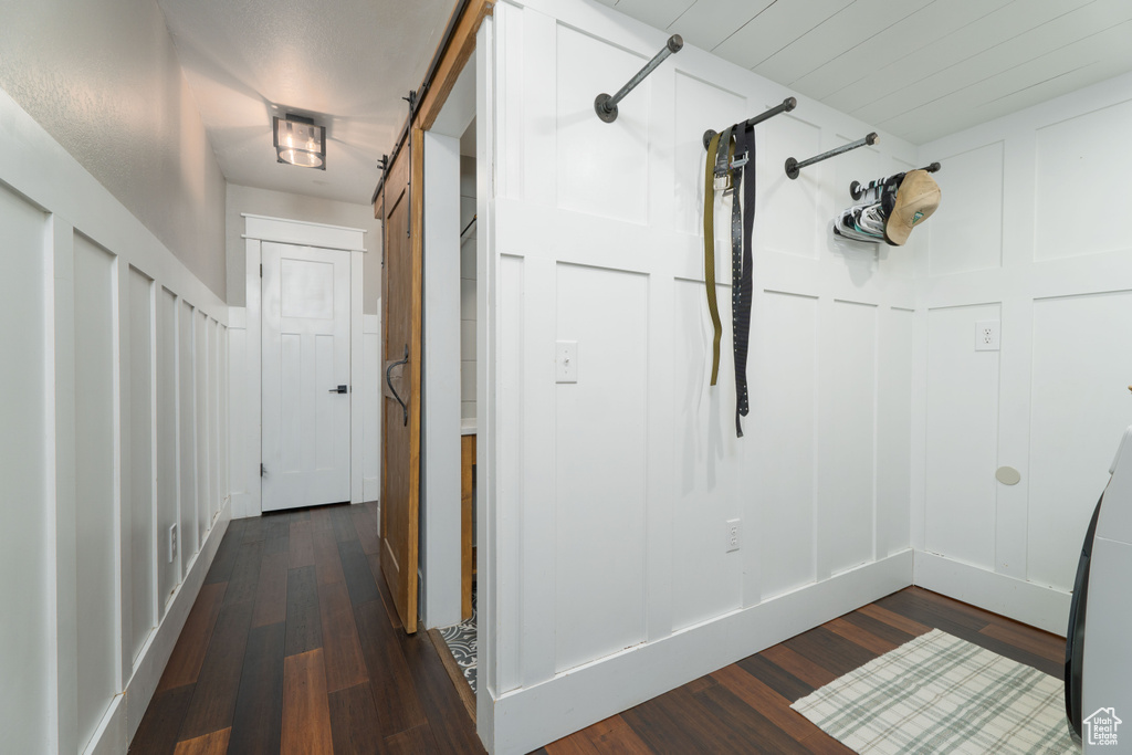 Corridor featuring a barn door and dark hardwood / wood-style flooring