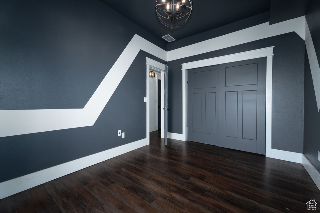 Interior space featuring dark wood-type flooring and an inviting chandelier