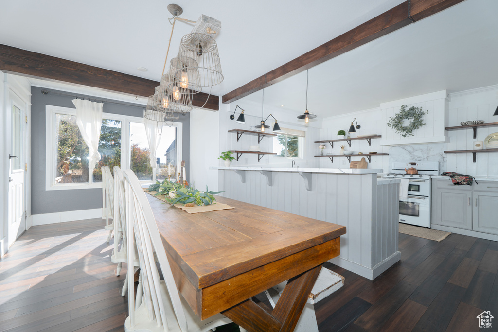 Dining area featuring beam ceiling and dark wood-type flooring