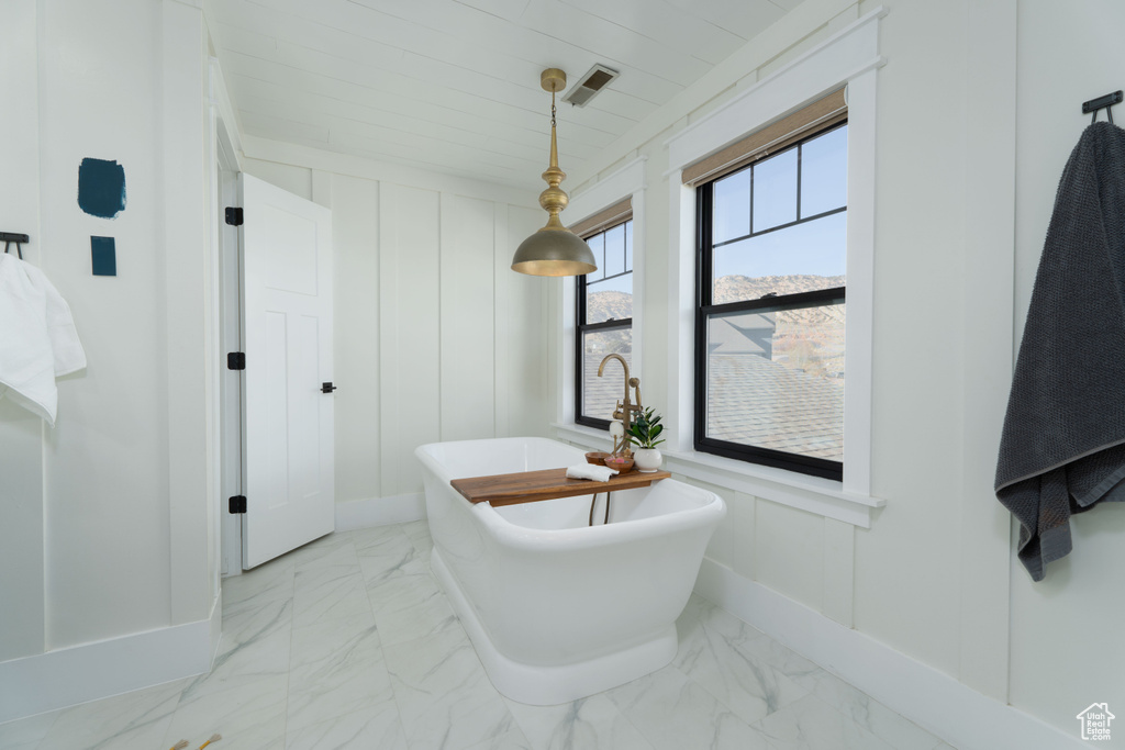 Bathroom featuring a bathtub and wood ceiling