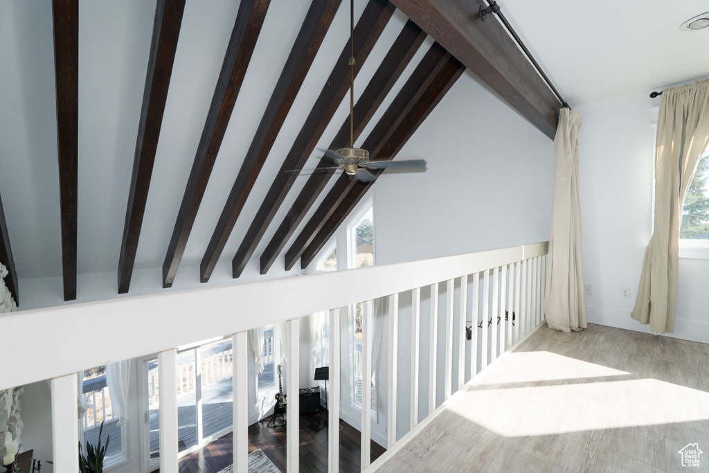 Stairway with beam ceiling, high vaulted ceiling, ceiling fan, and wood-type flooring