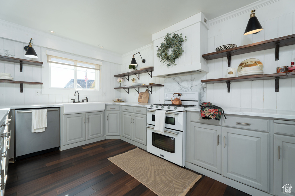 Kitchen with sink, stainless steel dishwasher, dark hardwood / wood-style floors, crown molding, and double oven range