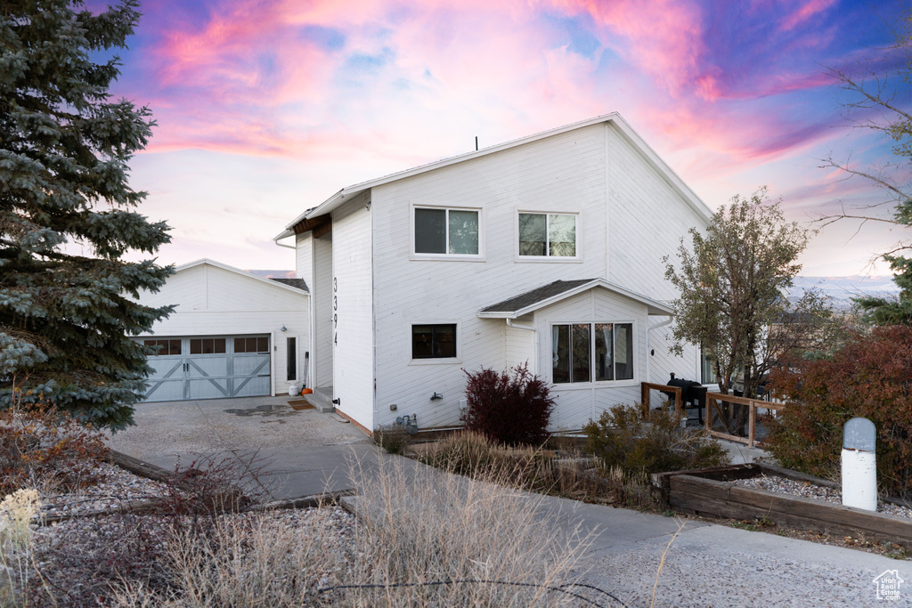 View of front of home with a garage and an outdoor structure