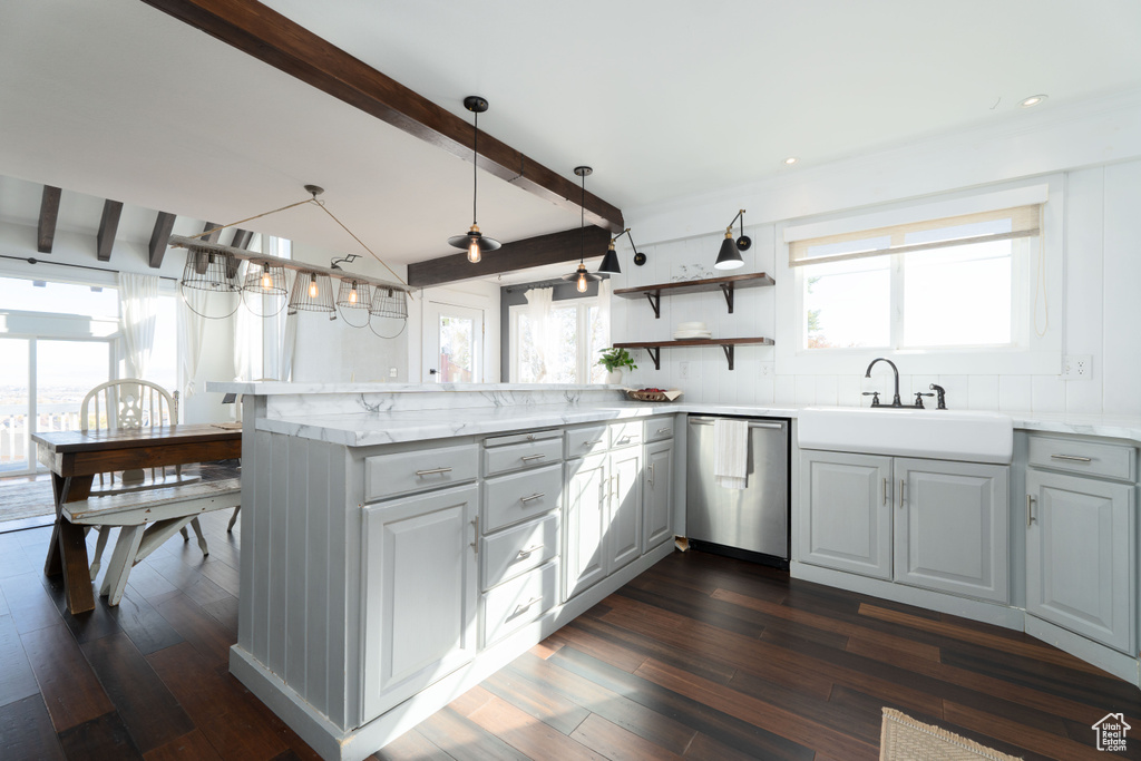 Kitchen featuring kitchen peninsula, dark wood-type flooring, beamed ceiling, and stainless steel dishwasher