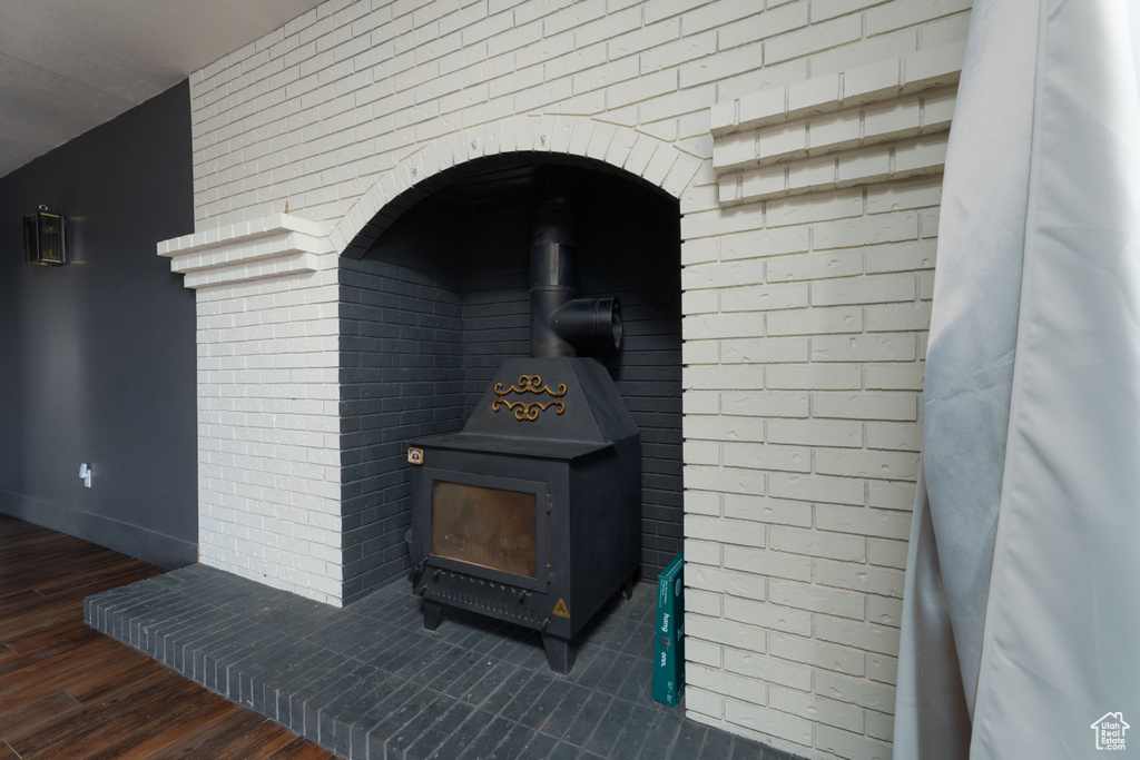 Room details featuring wood-type flooring and a wood stove