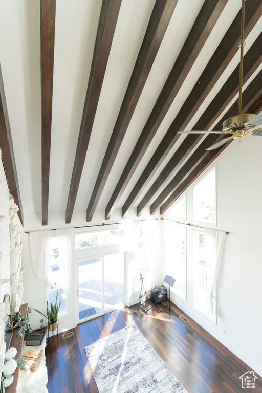 Living room with a wealth of natural light, dark wood-type flooring, and ceiling fan