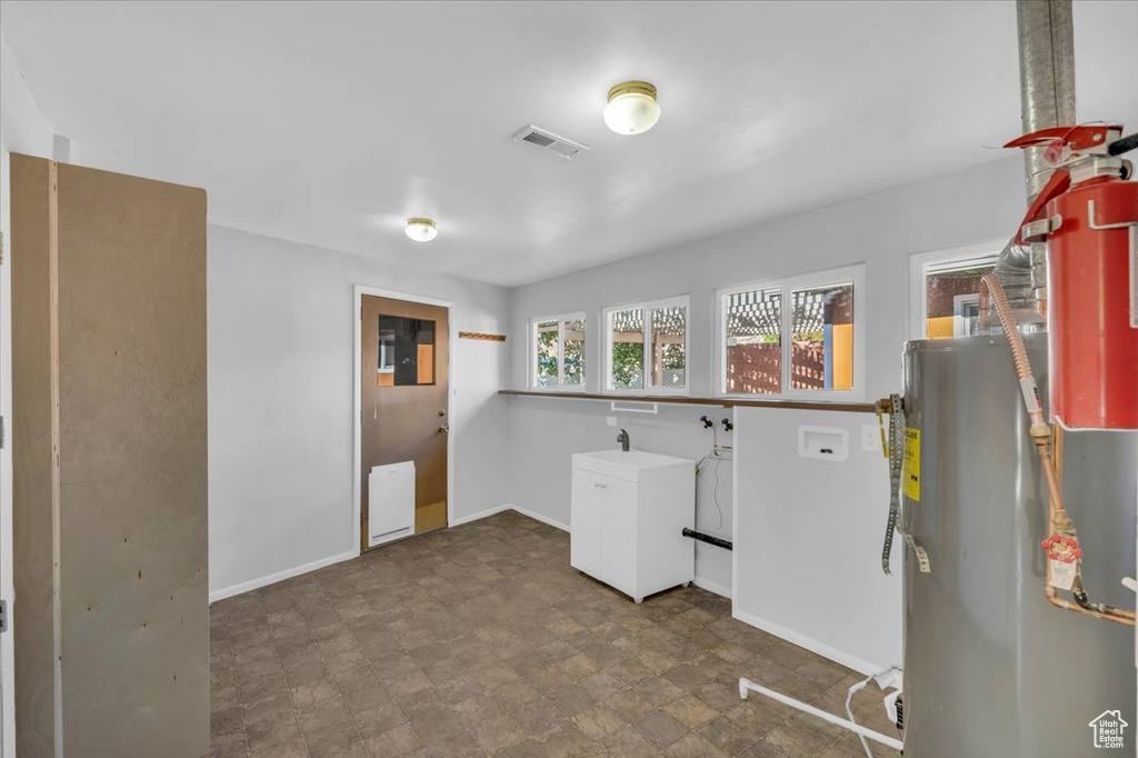 Laundry room featuring water heater, washer hookup, and electric dryer hookup