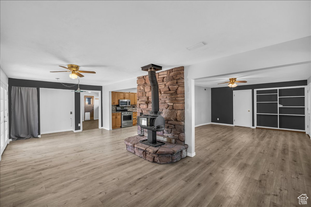 Unfurnished living room with a wood stove and light wood-type flooring