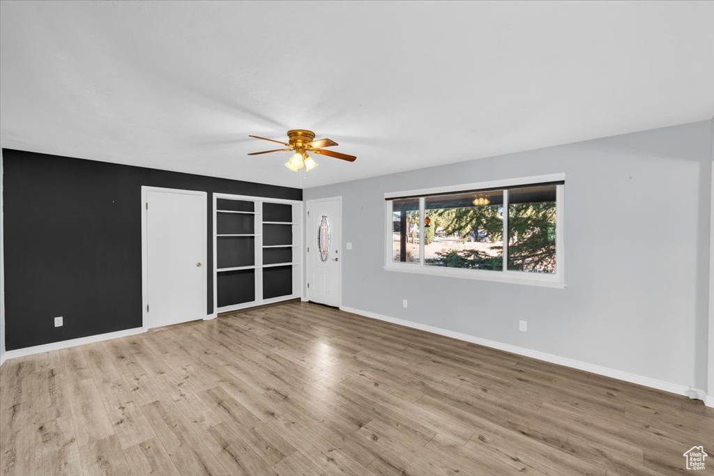 Unfurnished room featuring light wood-type flooring and ceiling fan