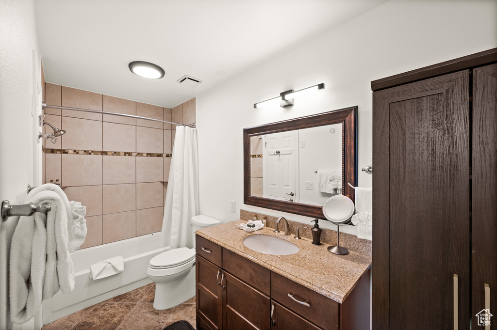 Full bathroom with toilet, vanity, shower / tub combo with curtain, and tile patterned flooring