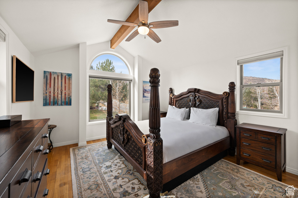 Bedroom with vaulted ceiling with beams, light hardwood / wood-style floors, and ceiling fan