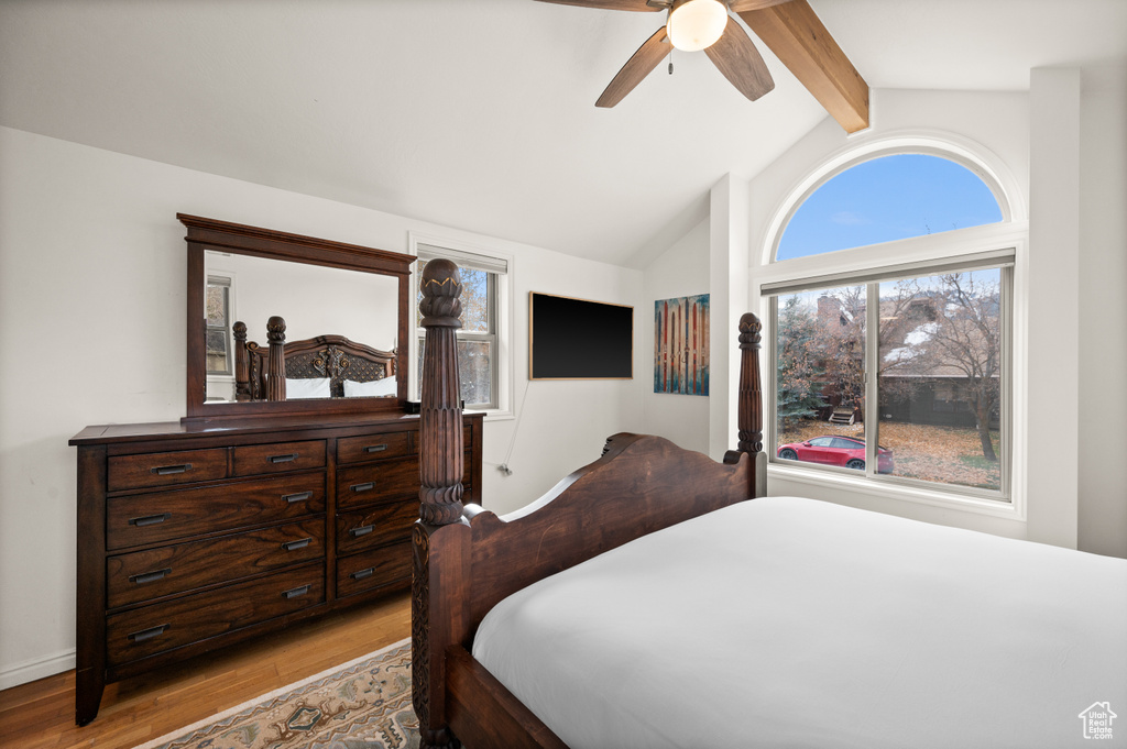Bedroom featuring vaulted ceiling with beams, light hardwood / wood-style flooring, and ceiling fan