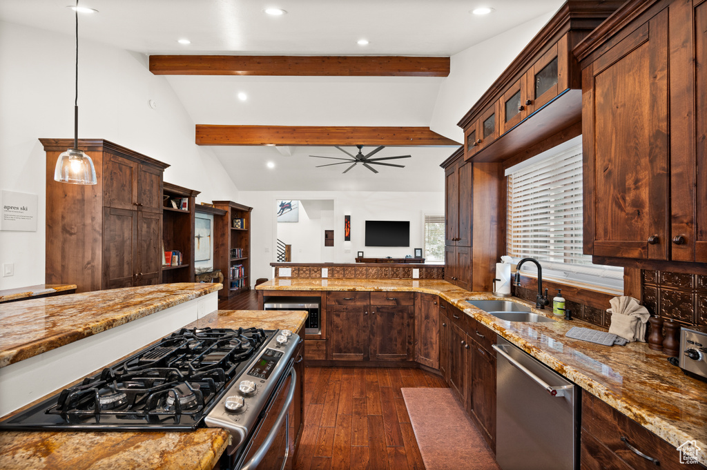 Kitchen with stainless steel appliances, sink, pendant lighting, lofted ceiling with beams, and dark hardwood / wood-style floors