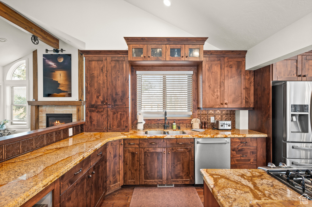 Kitchen featuring vaulted ceiling with beams, sink, a healthy amount of sunlight, and stainless steel appliances