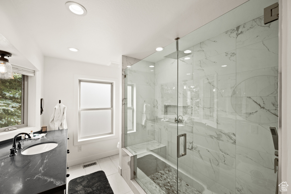 Bathroom with tile patterned flooring, vanity, and a shower with shower door
