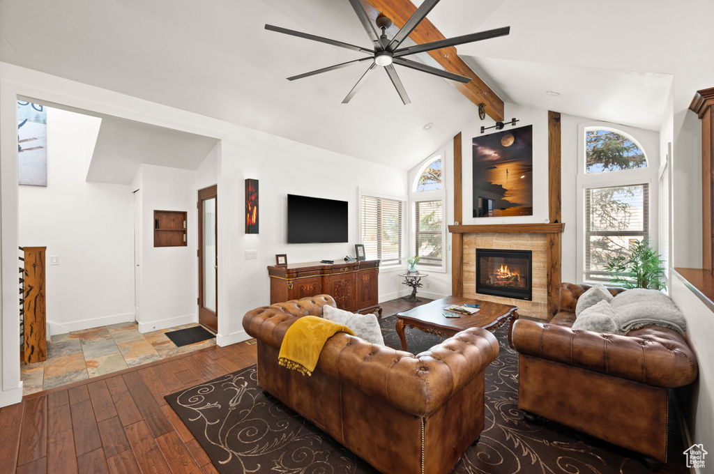 Living room featuring vaulted ceiling with beams, ceiling fan, and wood-type flooring