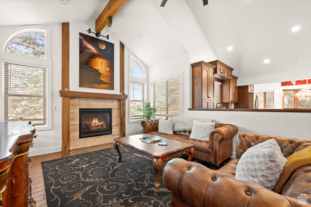 Living room with a fireplace, vaulted ceiling with beams, and hardwood / wood-style flooring
