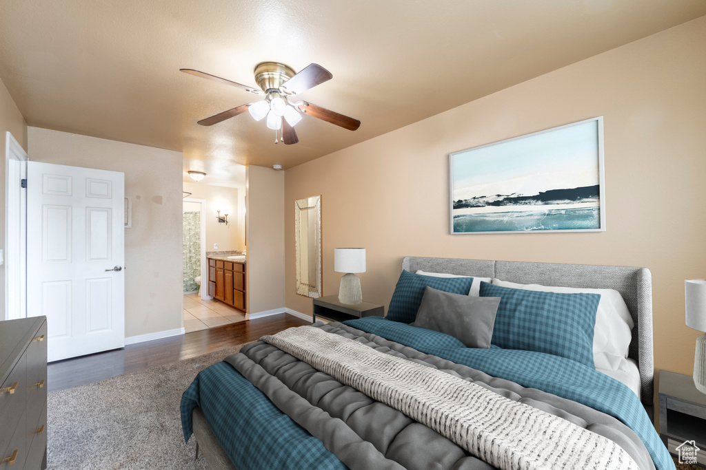 Bedroom with light wood-type flooring, ceiling fan, and connected bathroom