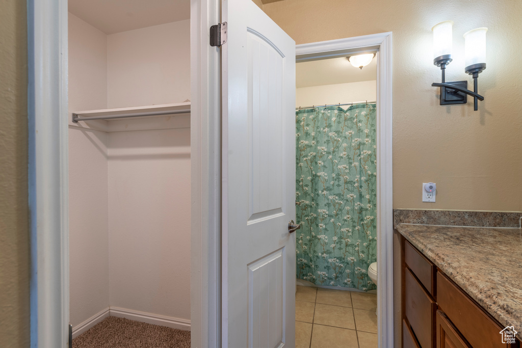 Bathroom with tile patterned floors, toilet, vanity, and walk in shower