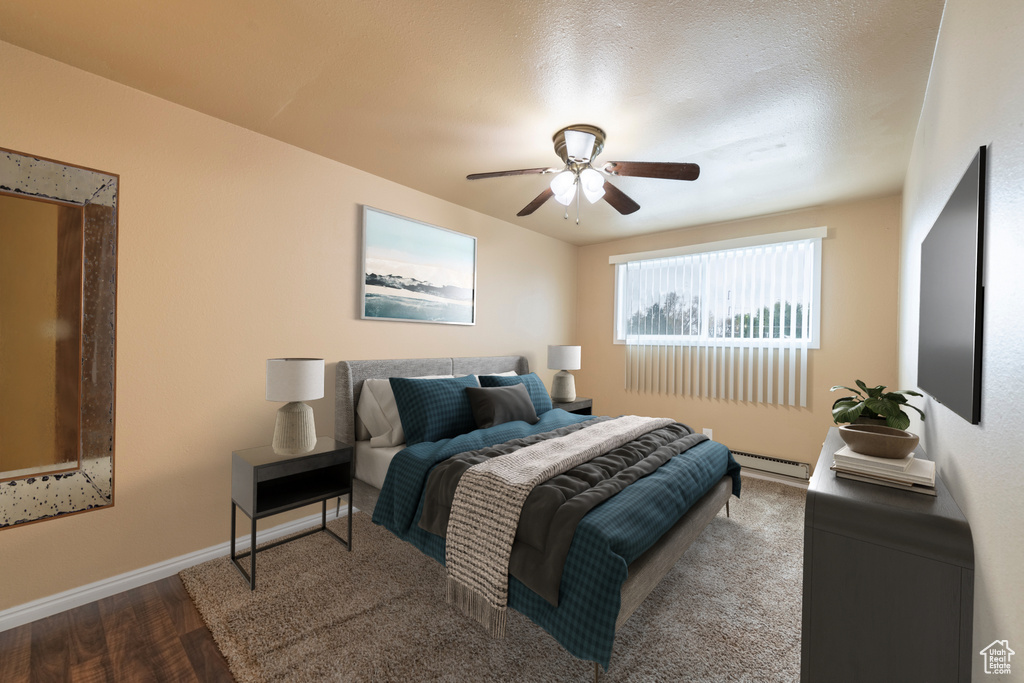 Bedroom with hardwood / wood-style floors, ceiling fan, a textured ceiling, and a baseboard heating unit