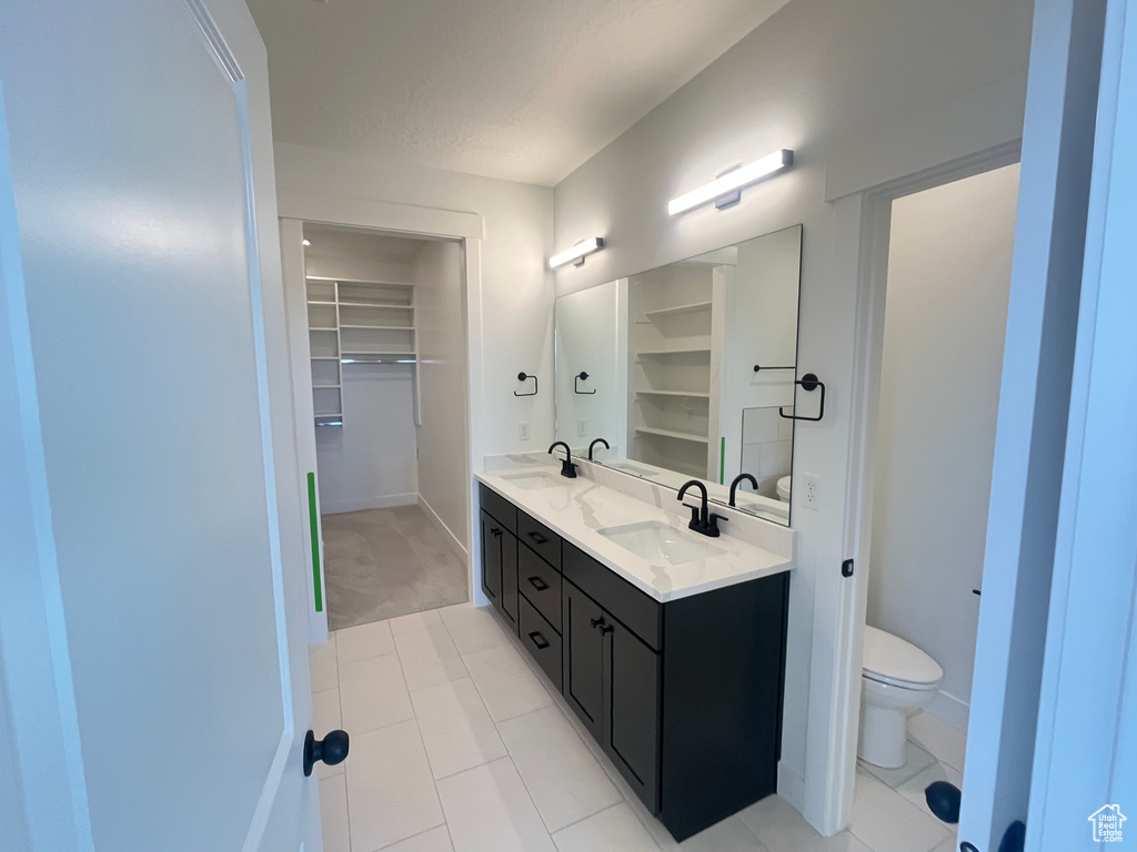 Bathroom with a sink, toilet, and double vanity
