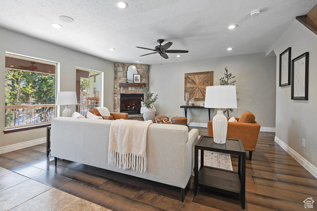 Living room with a fireplace, dark hardwood / wood-style flooring, and a textured ceiling