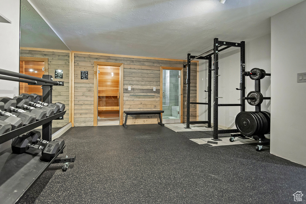 Workout room featuring a textured ceiling and wooden walls