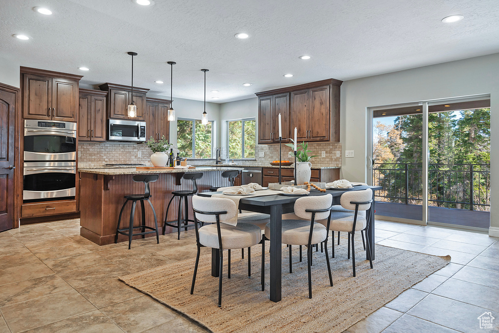 Dining room featuring light tile patterned floors and a textured ceiling