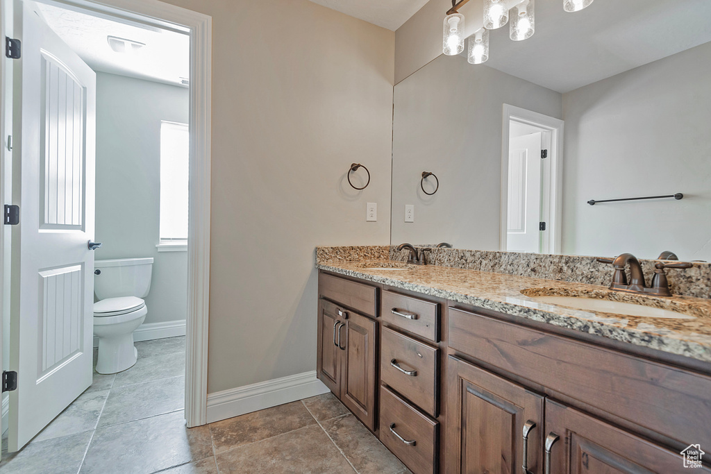 Bathroom featuring tile patterned floors, vanity, and toilet