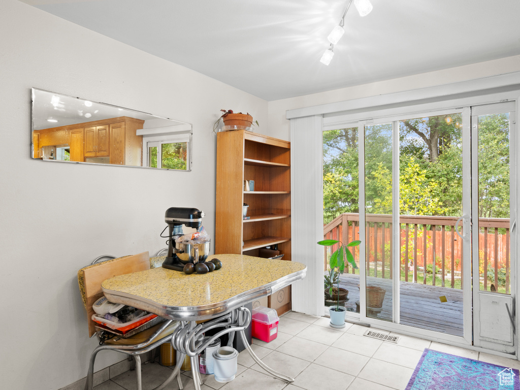 Dining room featuring a wealth of natural light, rail lighting, and light tile patterned floors