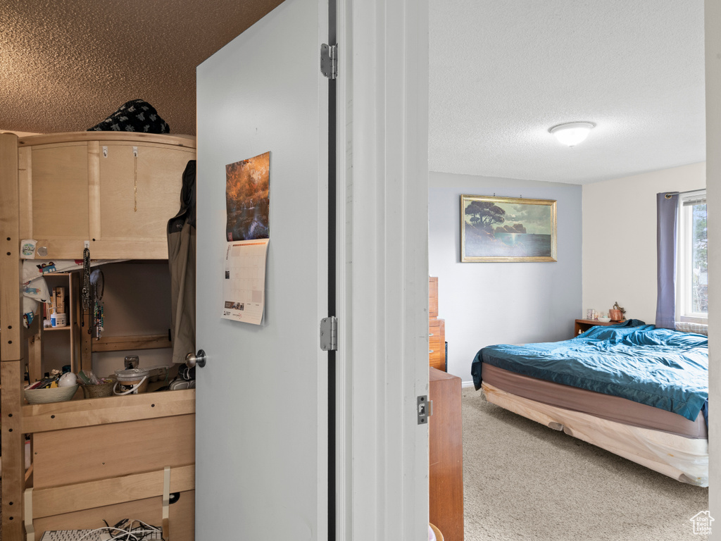 Carpeted bedroom with a textured ceiling