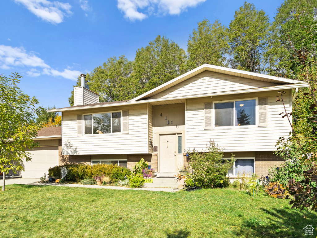 Raised ranch with a garage and a front lawn