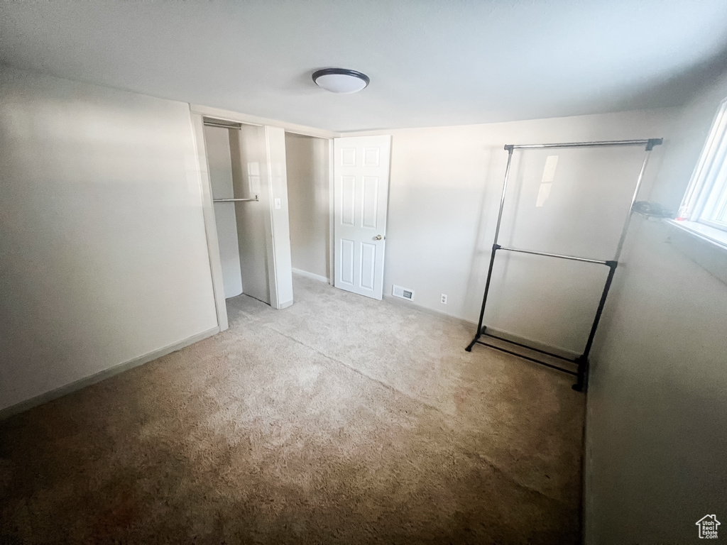 Unfurnished bedroom featuring carpet and baseboards