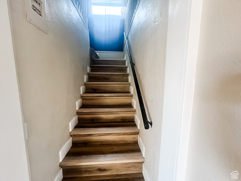 Staircase with wood finished floors and baseboards