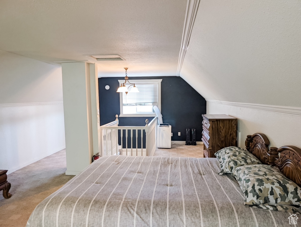 Carpeted bedroom with lofted ceiling and a textured ceiling
