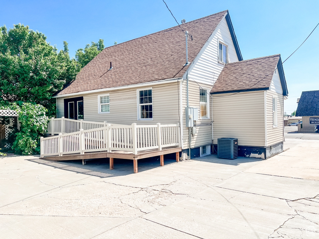 Rear view of property featuring a deck and a shingled roof