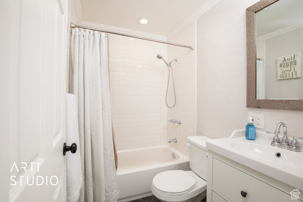 Full bathroom featuring toilet, vanity, shower / tub combo with curtain, and crown molding