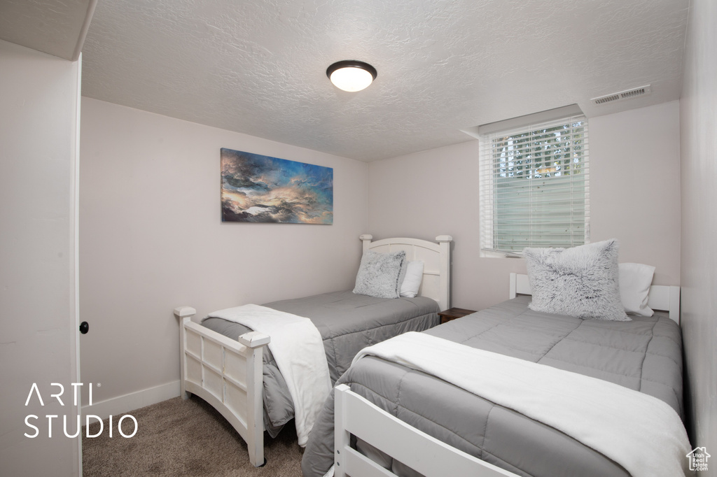 Bedroom featuring carpet and a textured ceiling