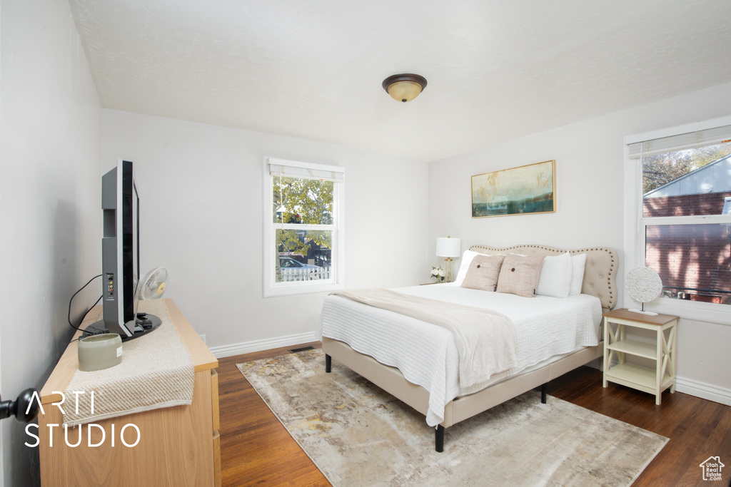 Bedroom featuring dark hardwood / wood-style flooring and multiple windows