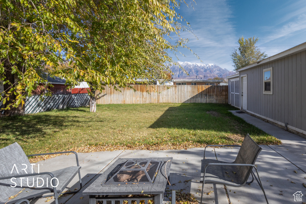 View of yard featuring a mountain view, a patio area, and an outdoor fire pit