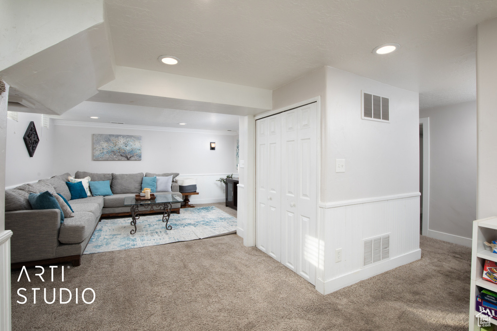 Living room with crown molding and carpet