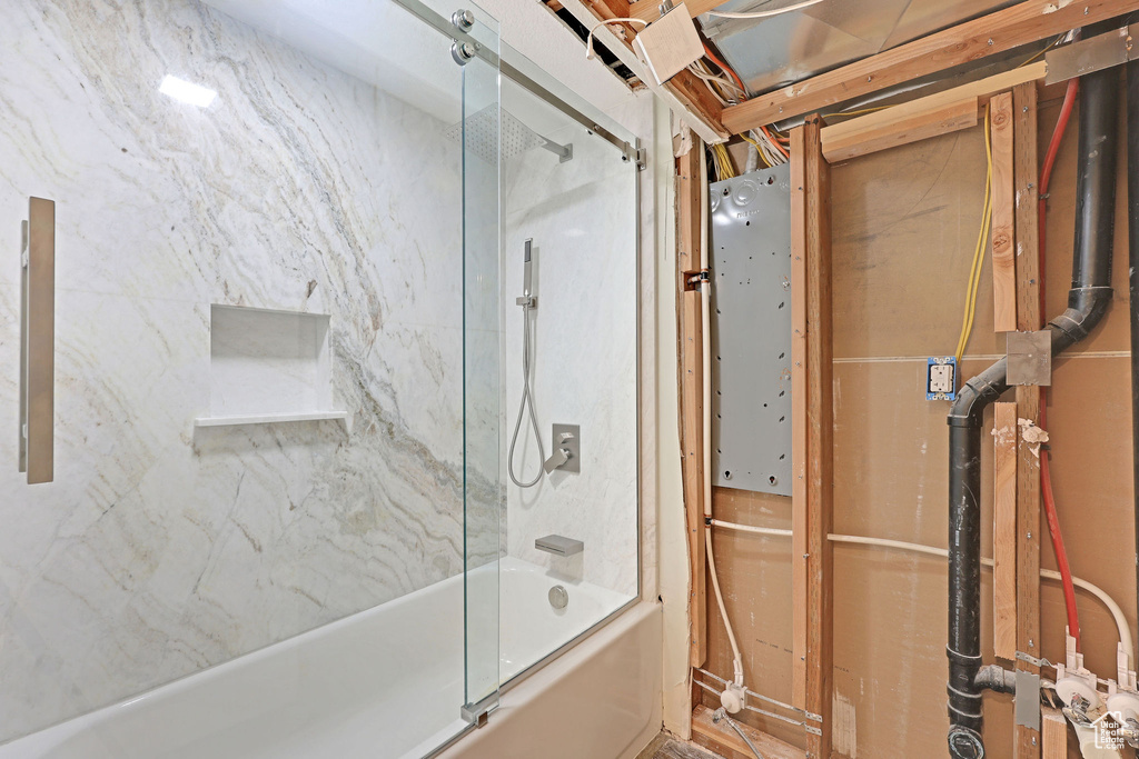 Bathroom featuring bath / shower combo with glass door