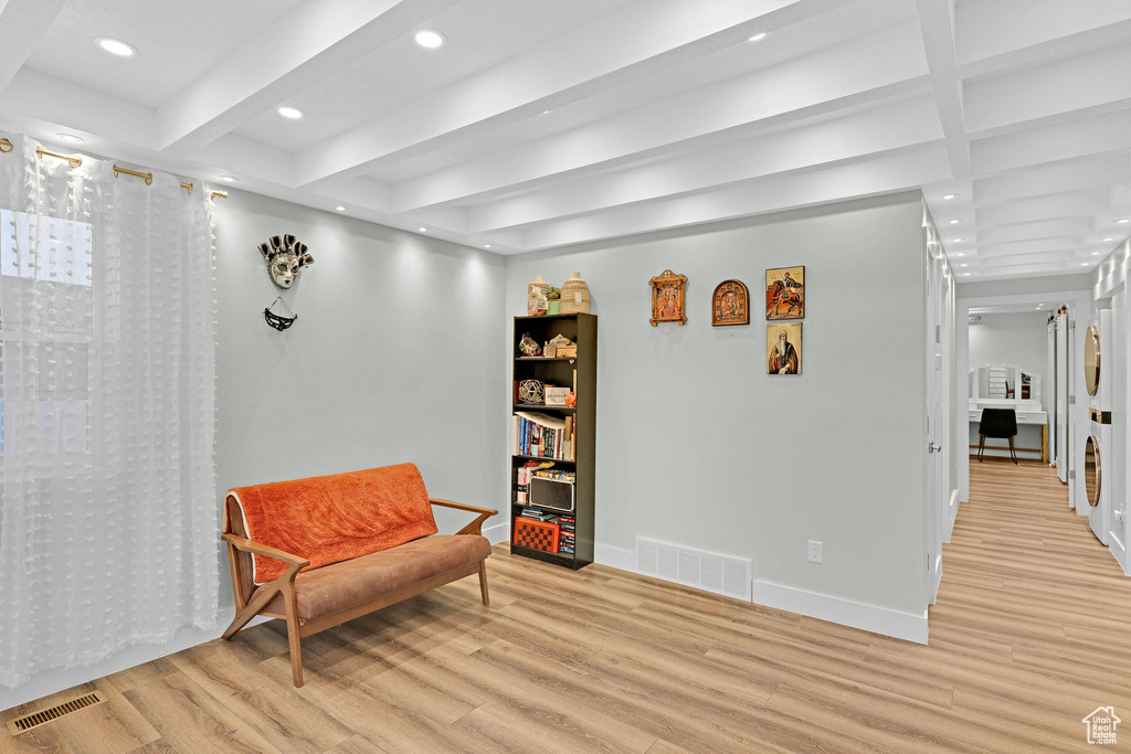 Living area featuring beamed ceiling and light hardwood / wood-style flooring