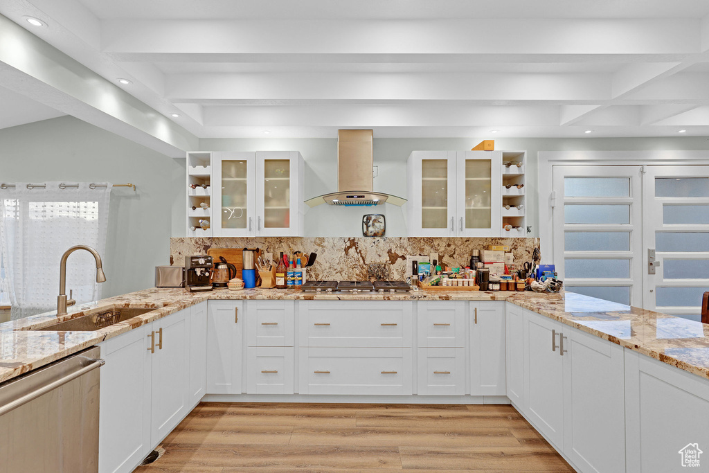 Kitchen with tasteful backsplash, wall chimney range hood, sink, and stainless steel appliances