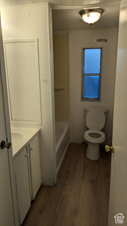 Bathroom featuring hardwood / wood-style floors, a textured ceiling, and toilet