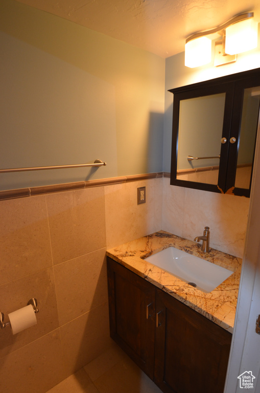 Bathroom featuring vanity and tile walls