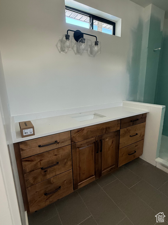 Bathroom with walk in shower, vanity, and tile patterned floors